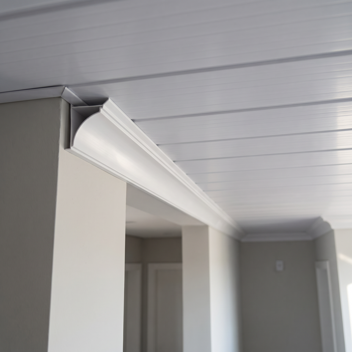 Meia cana de PVC Neve instalada no encontro entre parede e forro branco em ambiente residencial